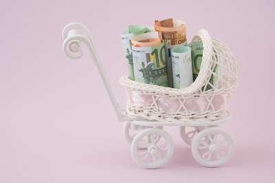 Foto: Miniaturkinderwagen mit Geldscheinen